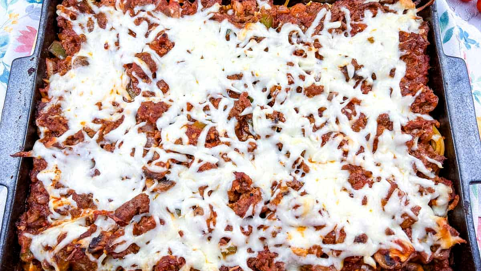 Spaghetti with meat and cheese in a baking dish.