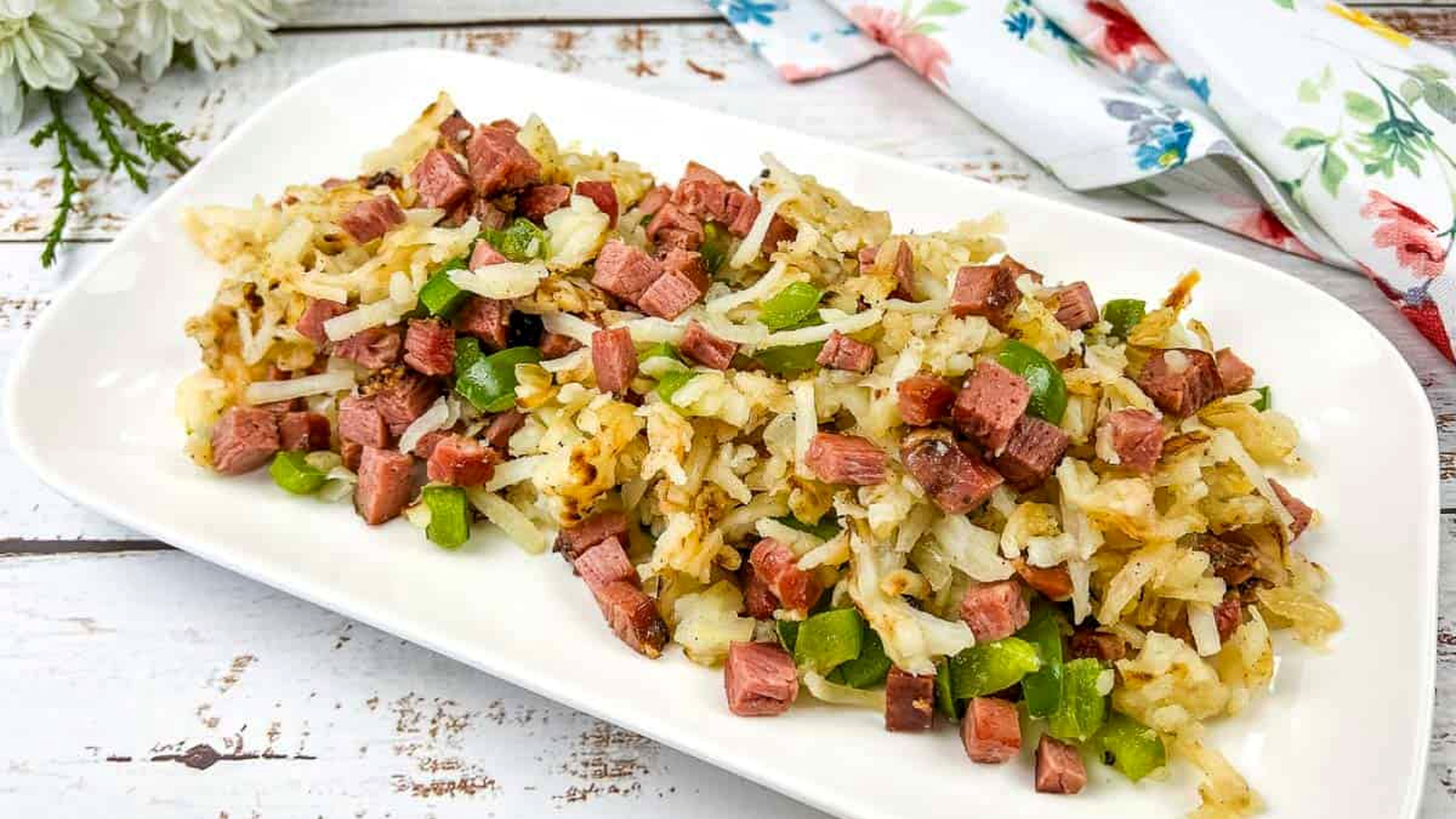 A white rectangular plate with Montreal smoked meat hash on it.