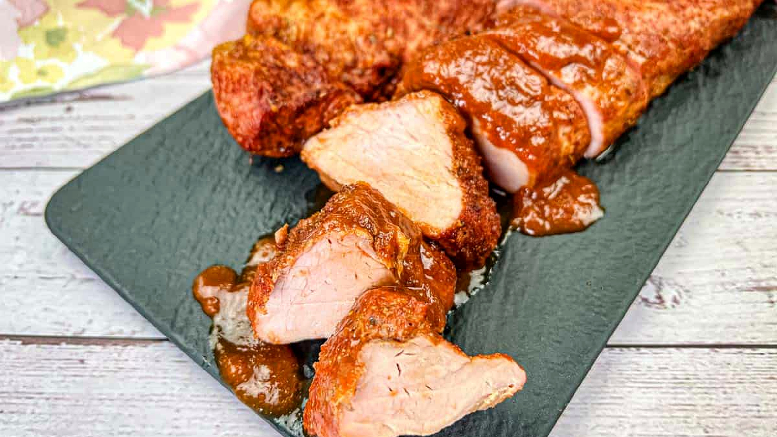 A plate of Ninja Woodfire Outdoor Grill-Smoked Pork Tenderloin with Mezcal BBQ Sauce.