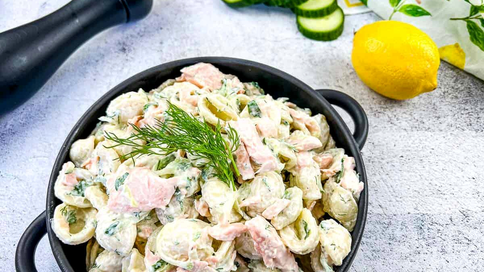Salmon pasta salad in a black dish.