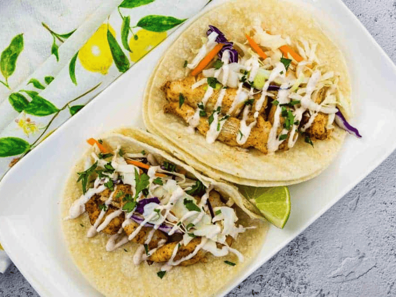 Baja fish tacos on a white plate.