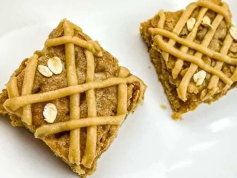 Two brown butter apple blondies were placed on a white surface.