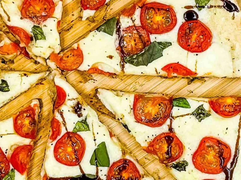 Caprese pizza sliced and ready to eat.