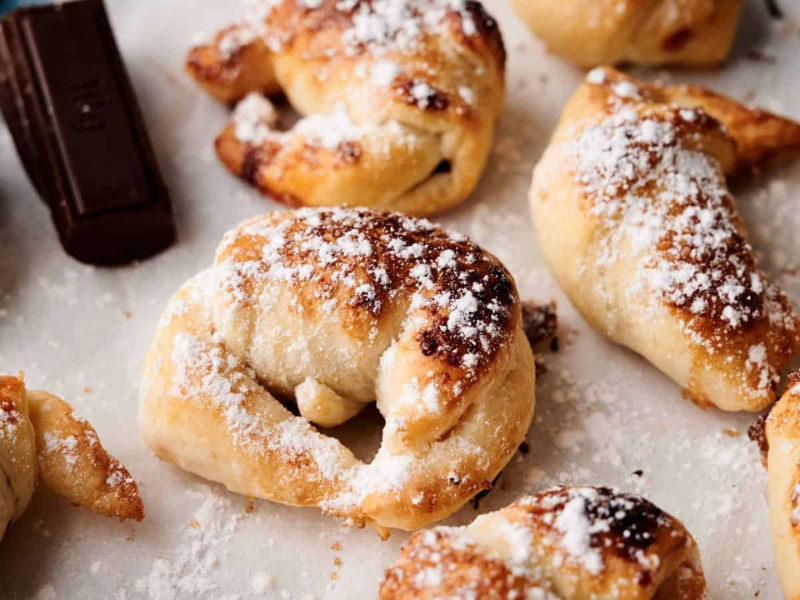 Chocolate and pretzel rolls with powdered sugar.