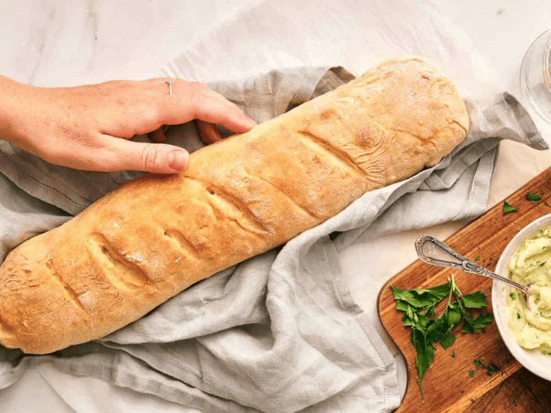 A person is holding French bread.
