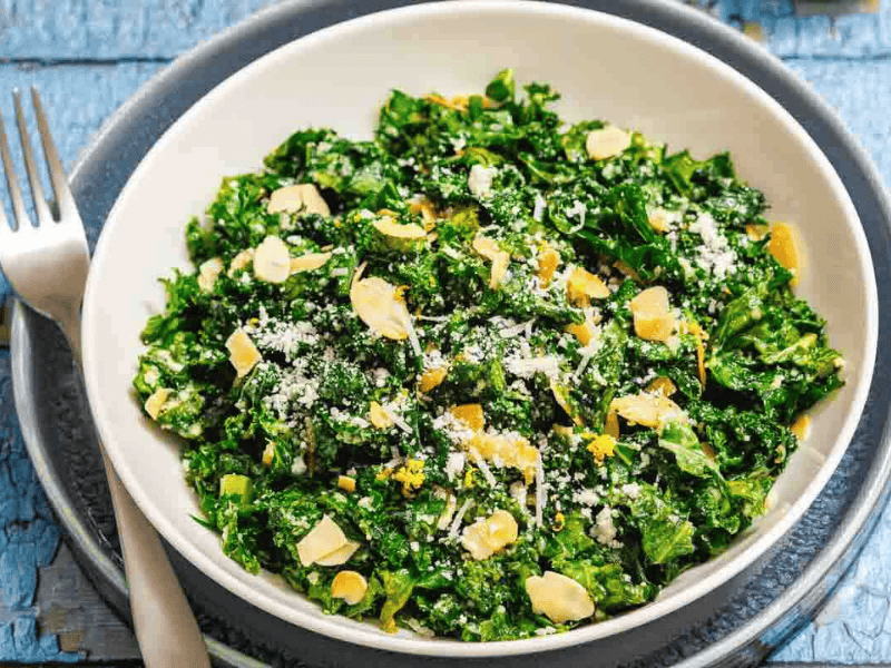 Green kale salad topped with sliced almonds.