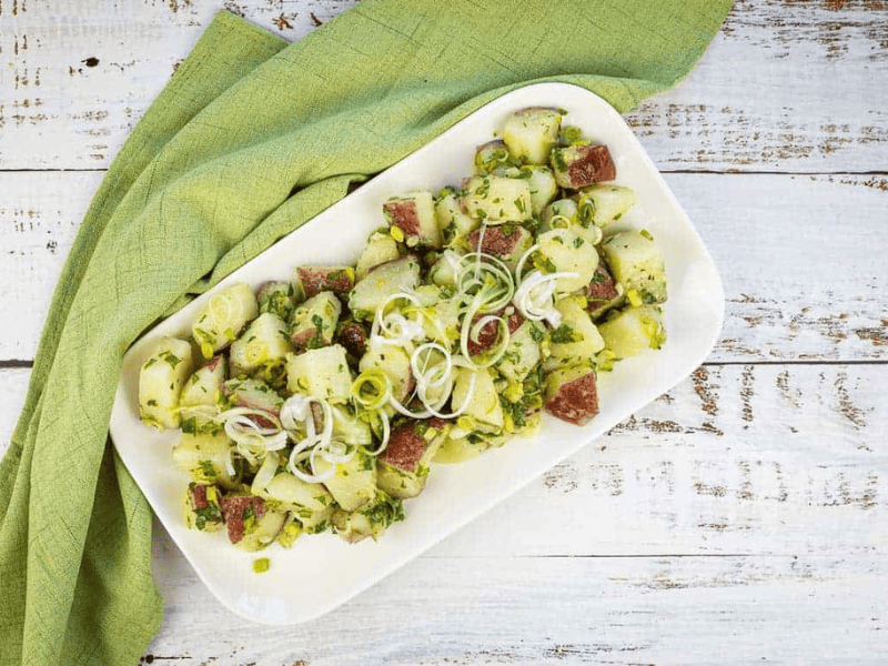 Herbed potato salad on a white platter.