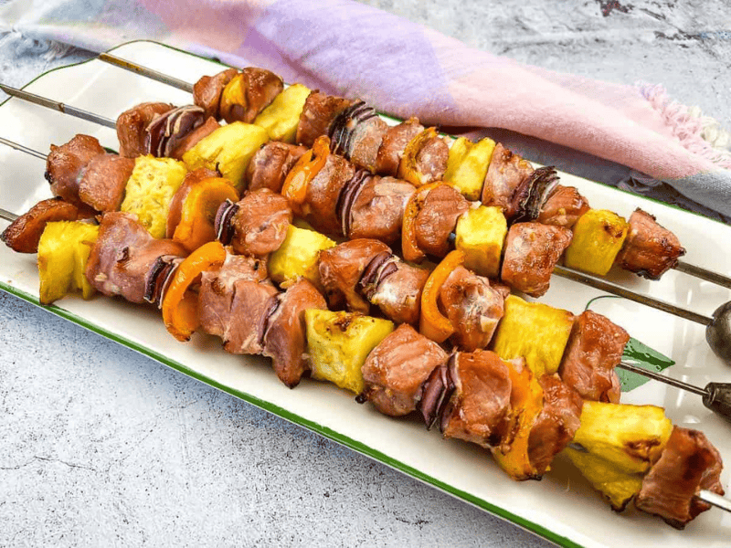 Smoked Pork & Pineapple Kabobs on a plate for serving.