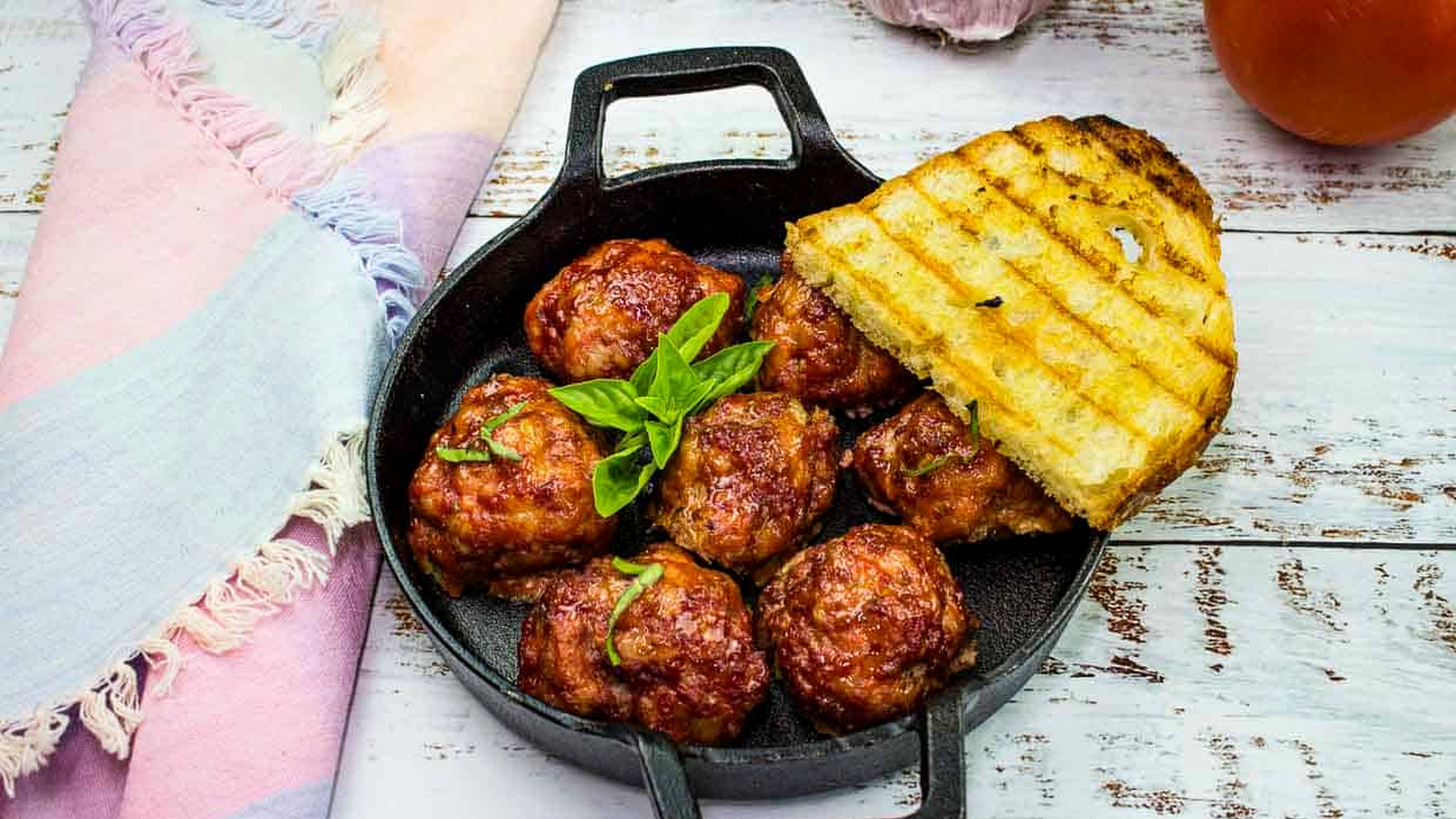 Smoked meatballs in a dish with grilled bread.