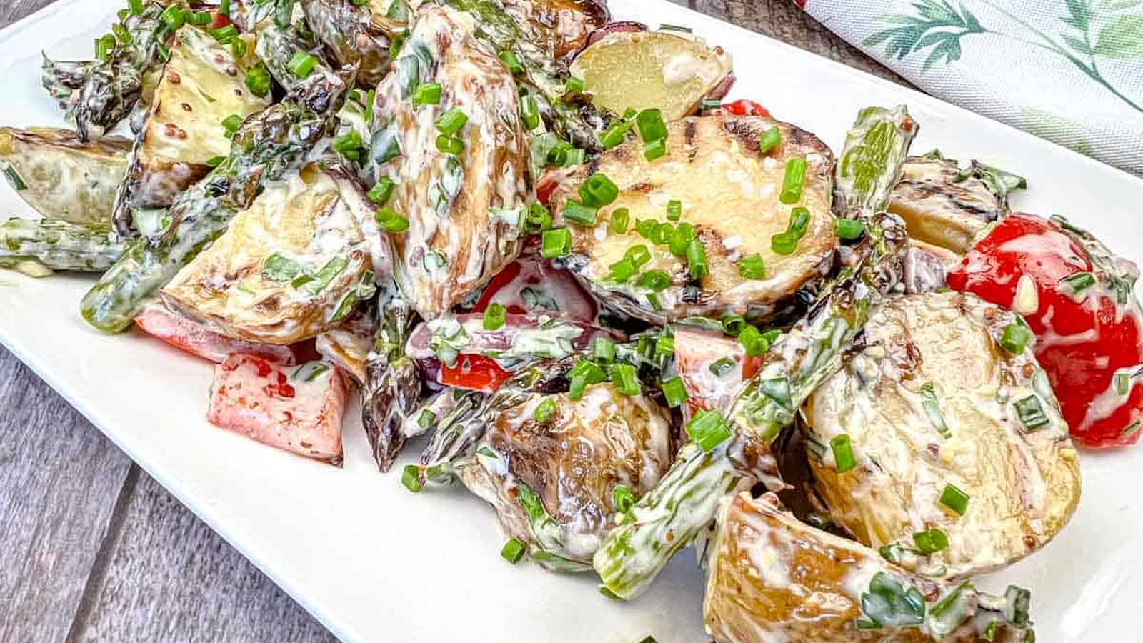 Close-up shot of Grilled Asparagus and Potato Salad on a white plate.