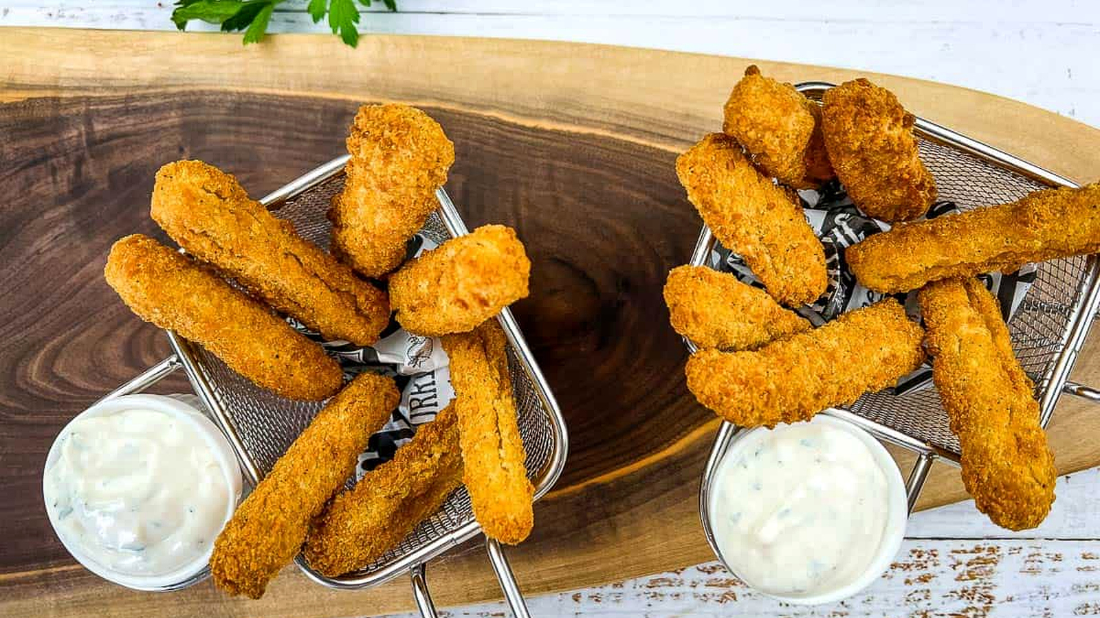 Air fried chicken fries with dipping sauce on a wooden cutting board.