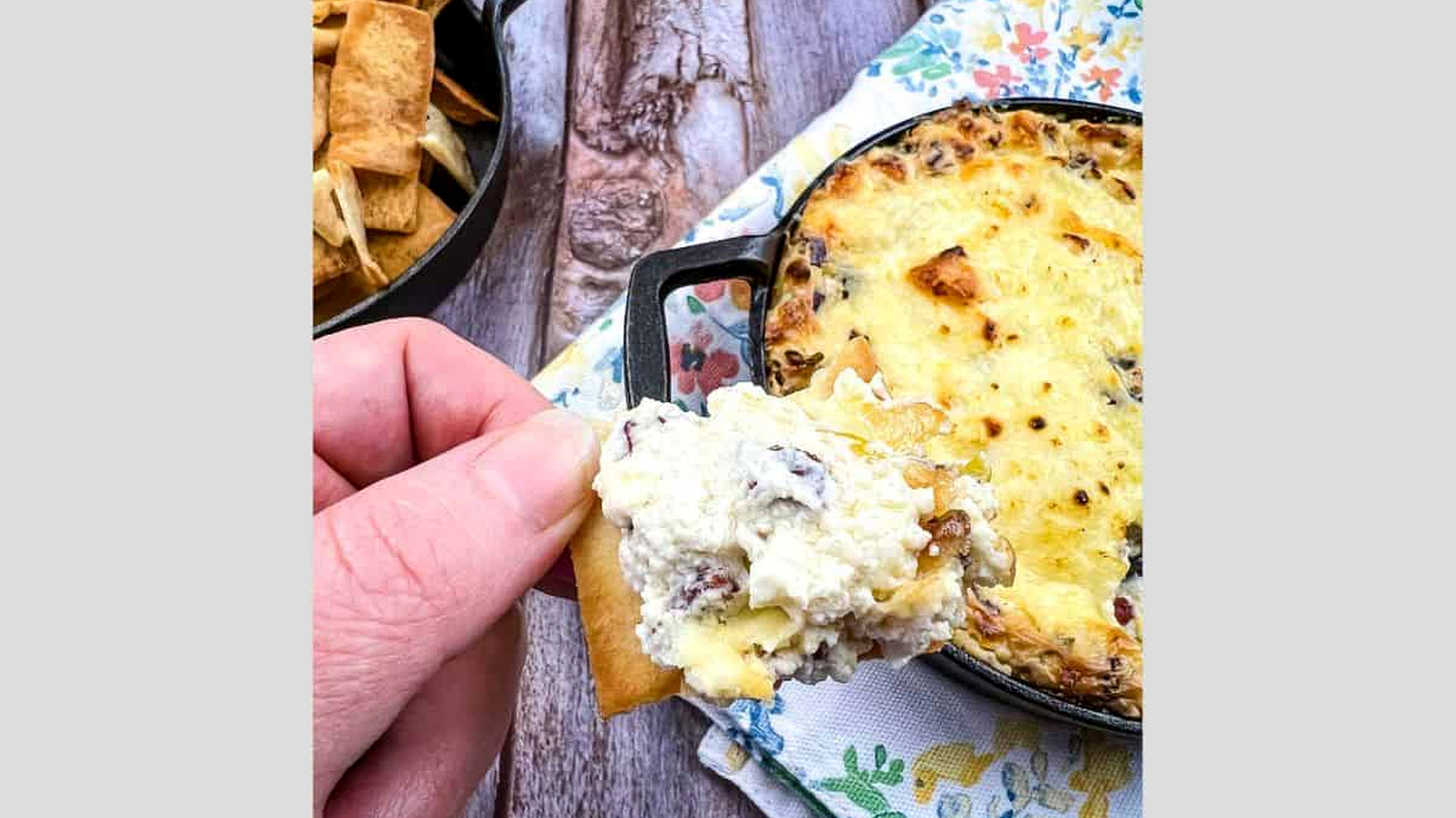 Beef jerky dip on a cracker held in a hand.