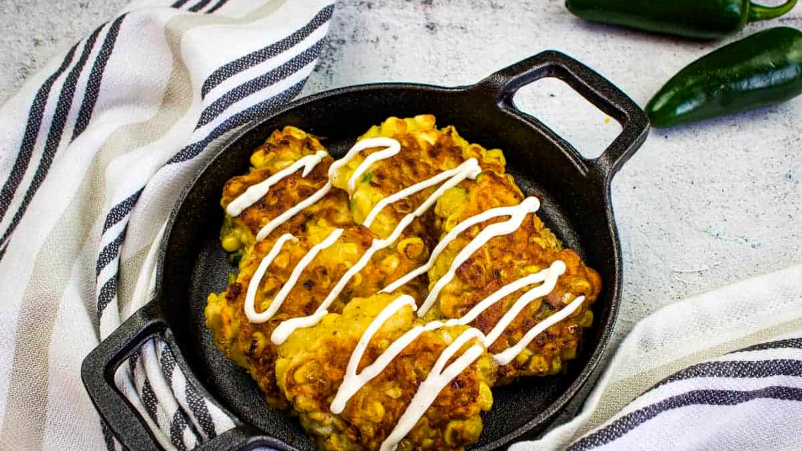 Corn fritters in a black cast iron pan.