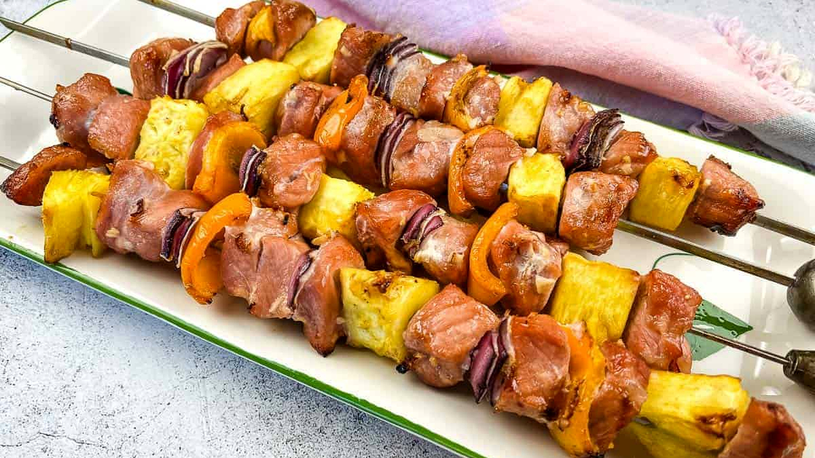 Smoked Pork & Pineapple Kabobs on a plate for serving.