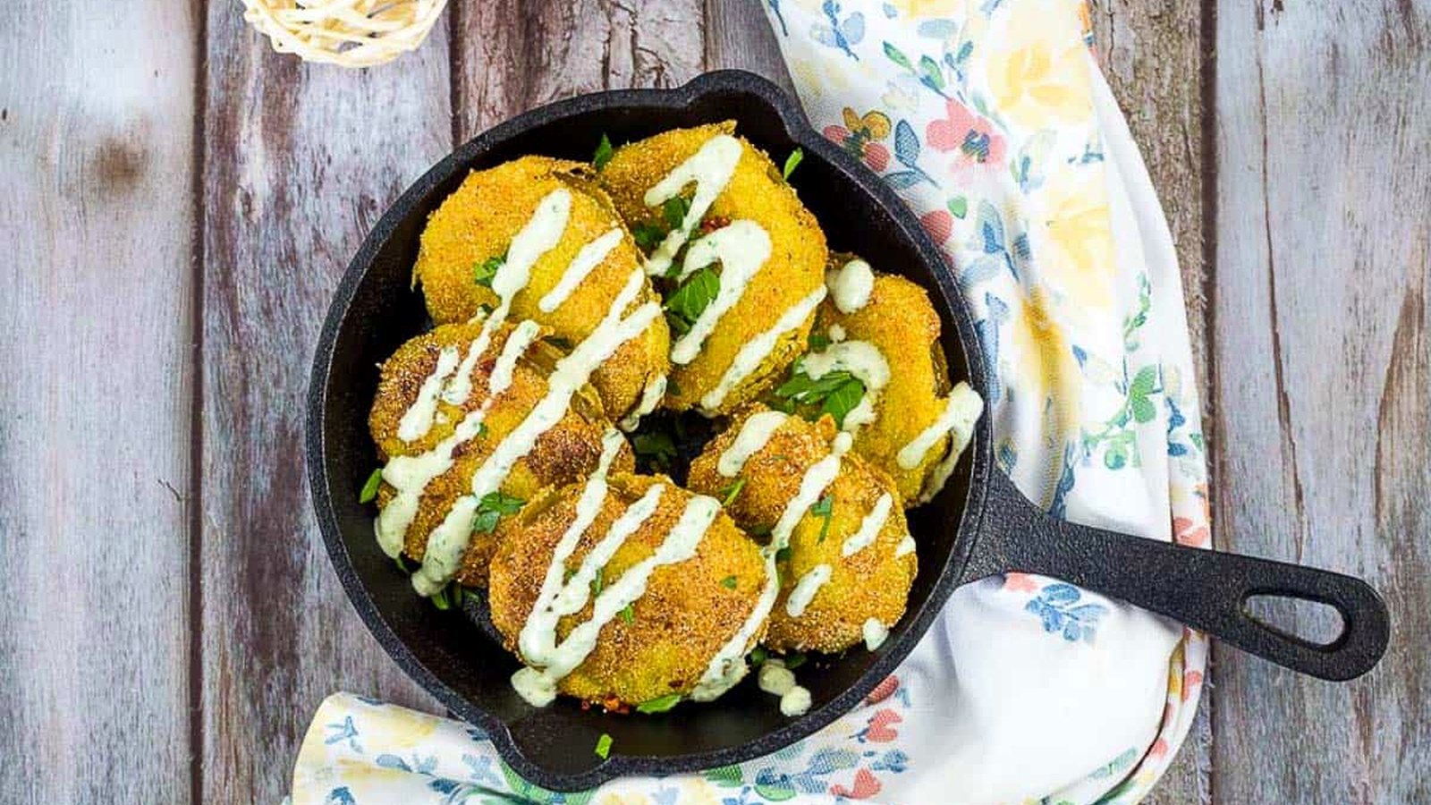 Fried Tomatillos in a black cast iron pan.