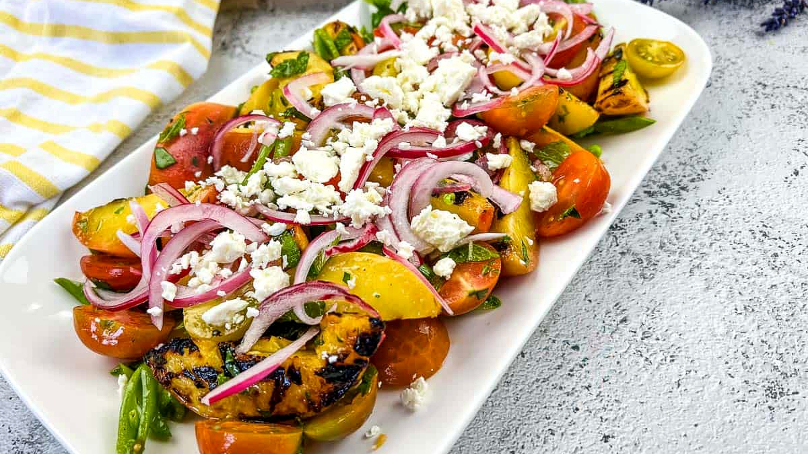 A plate with Grilled Peach Salad with Tomatoes.