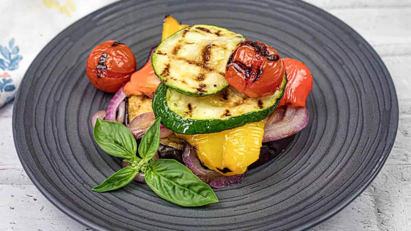 Close-up shot of Grilled Ratatouille on a black plate.