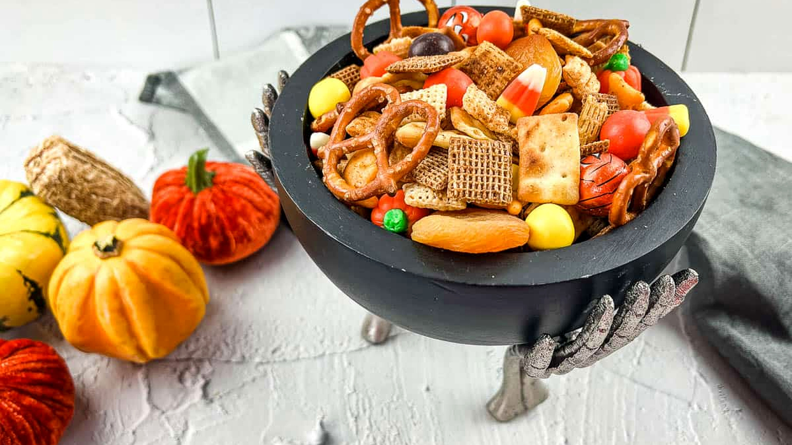 Spicy Chex Mix with Halloween Candies in a festive bowl.