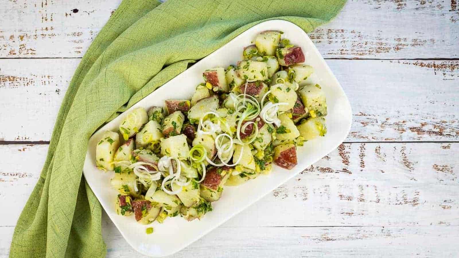 Herbed potato salad on a white platter.