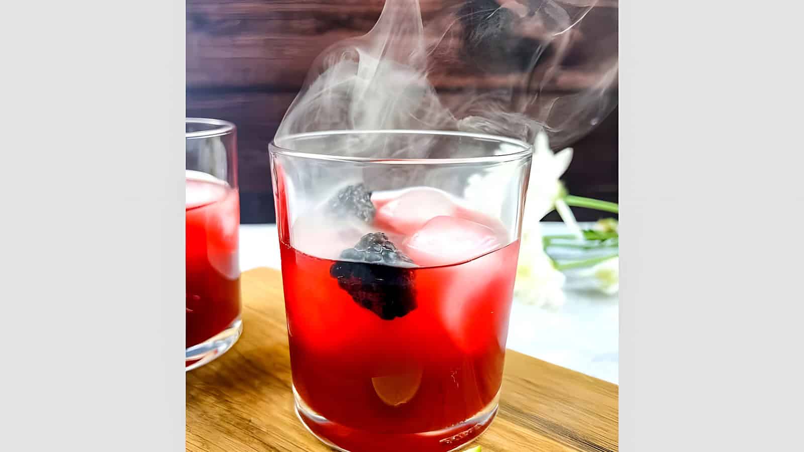 Smoked Blackberry Margarita with smoke coming out the top of the glass.