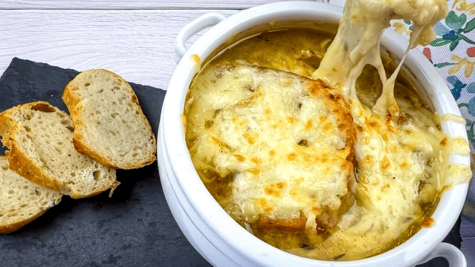 A bowl of French onion soup with bread on top.