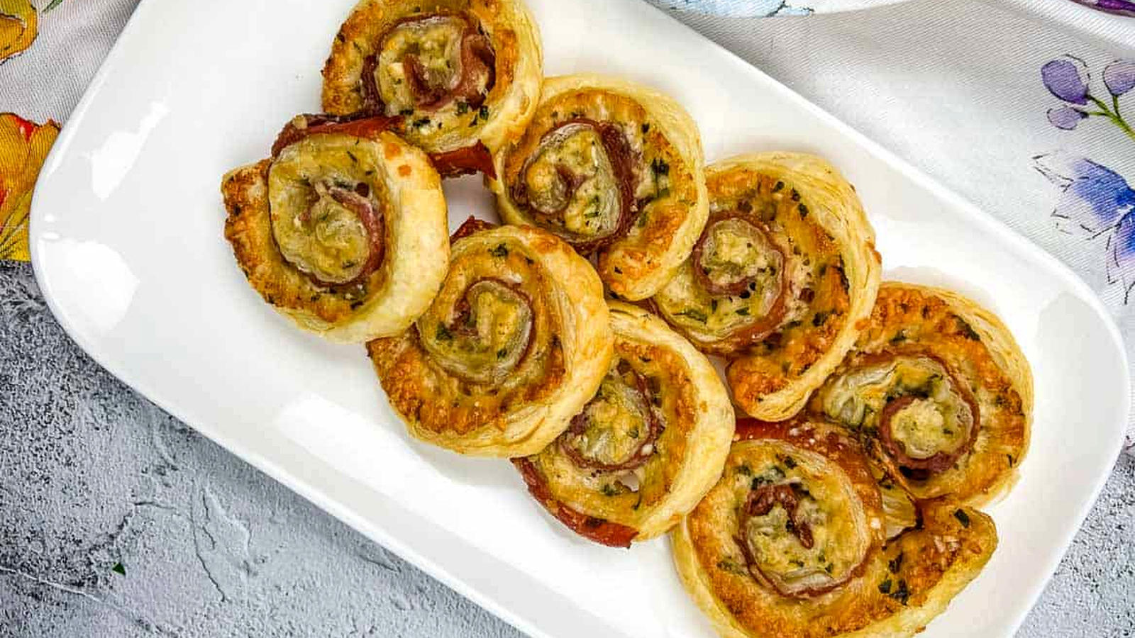 A plate of Prosciutto & Parmesan Puff Pastry pinwheels.