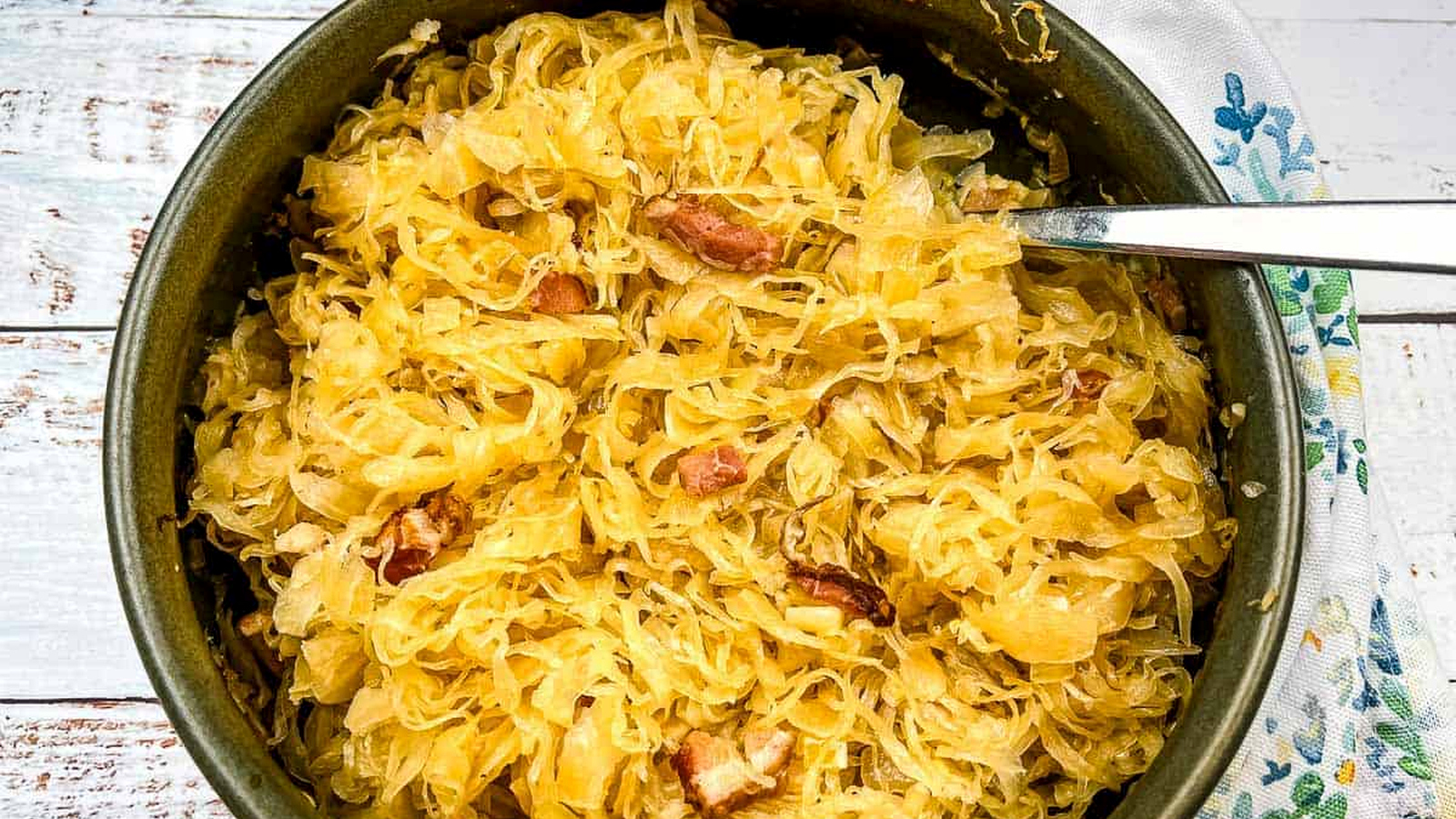Sauerkraut in a serving dish with a spoon.