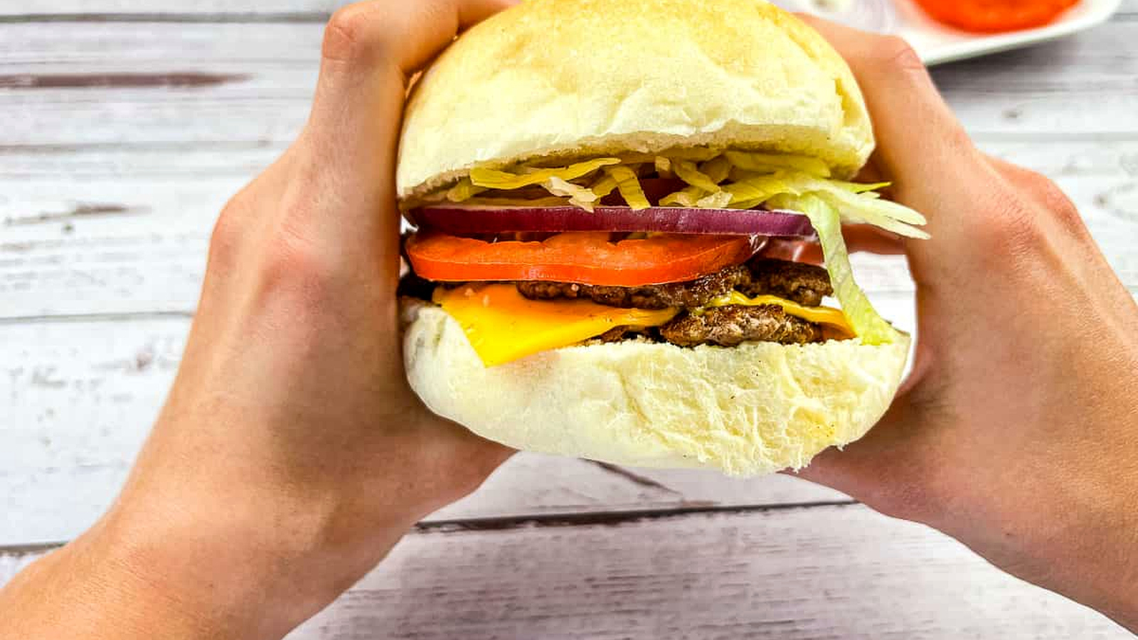 A burger held in two hands.
