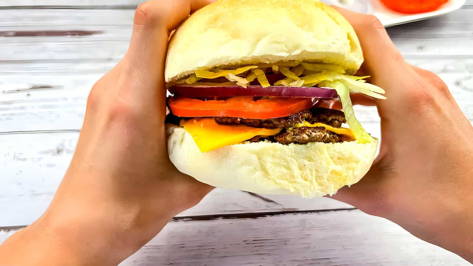 A burger held in two hands.