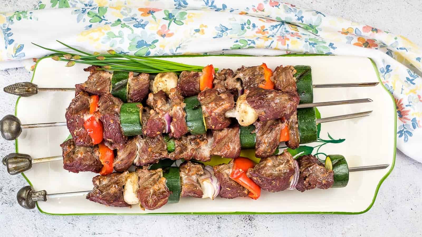 Smoked beef kabobs on a plate.