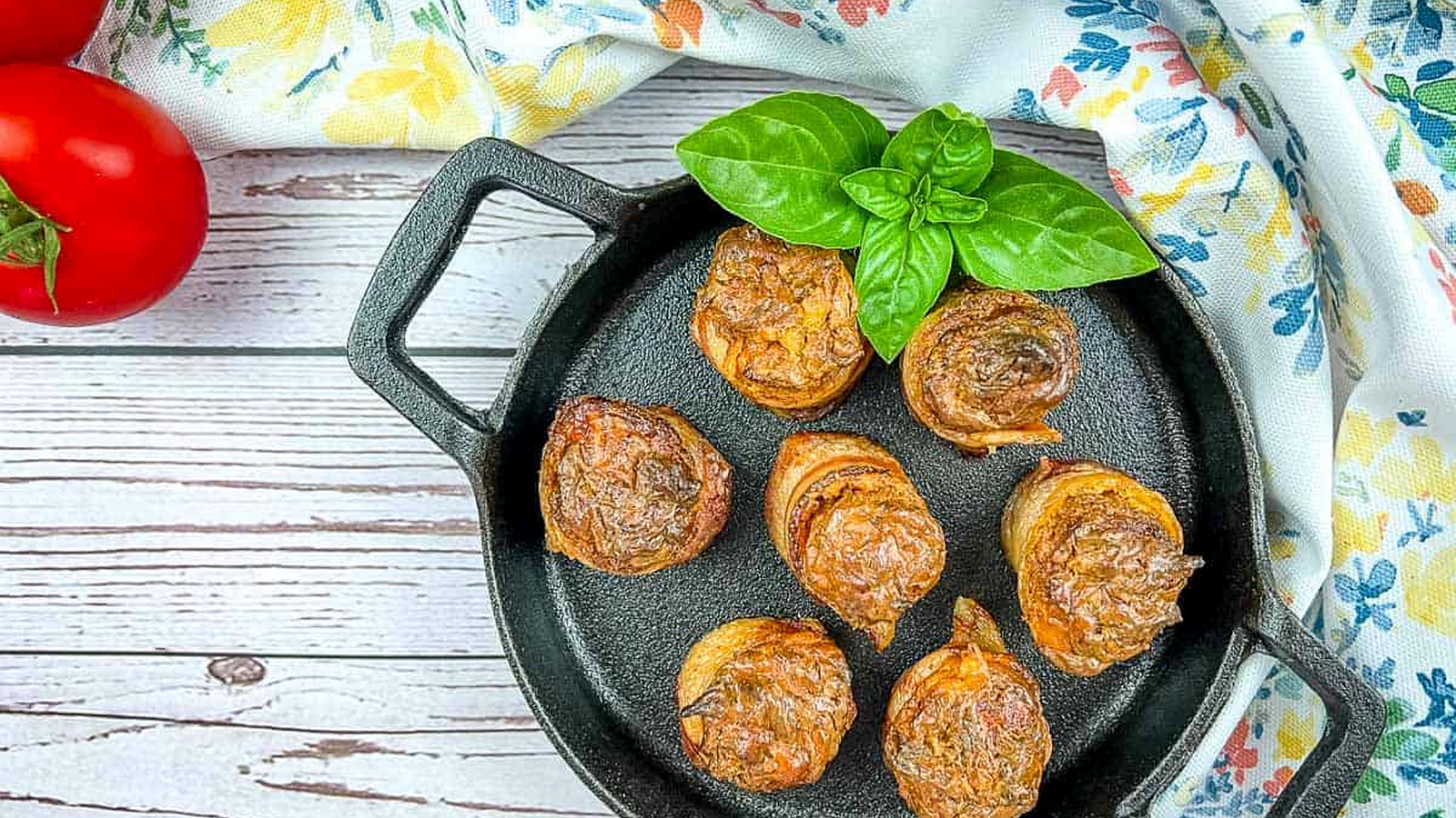 Smoked pork shots in a skillet with basil and tomatoes.