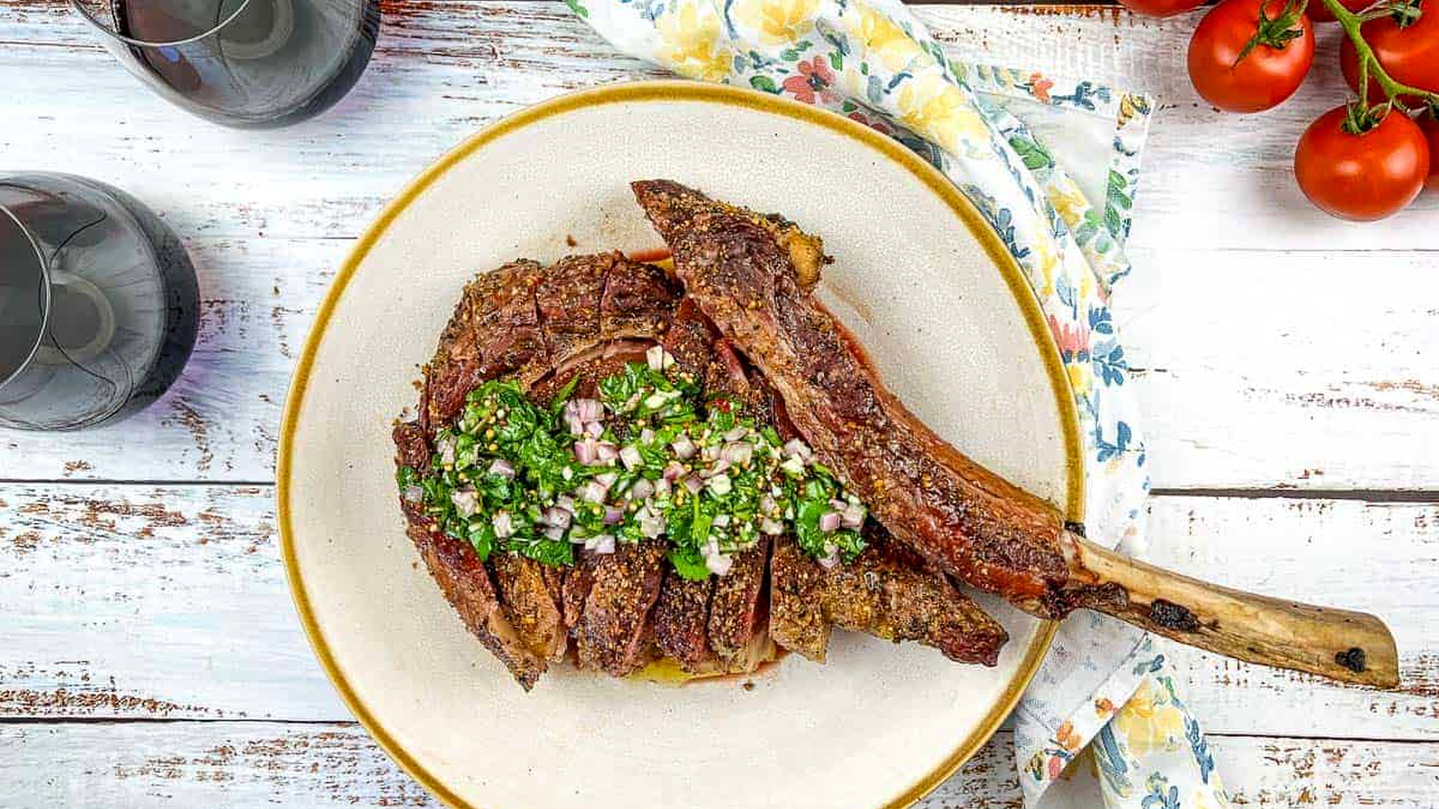 A sliced Tomahawk Steak on a cream color plate.