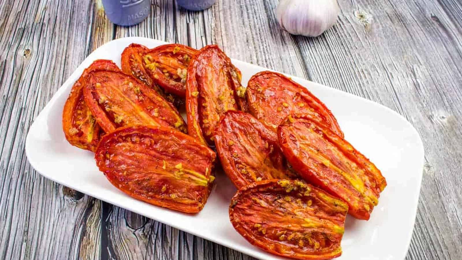 Smoked tomatoes in a dish with grilled bread.