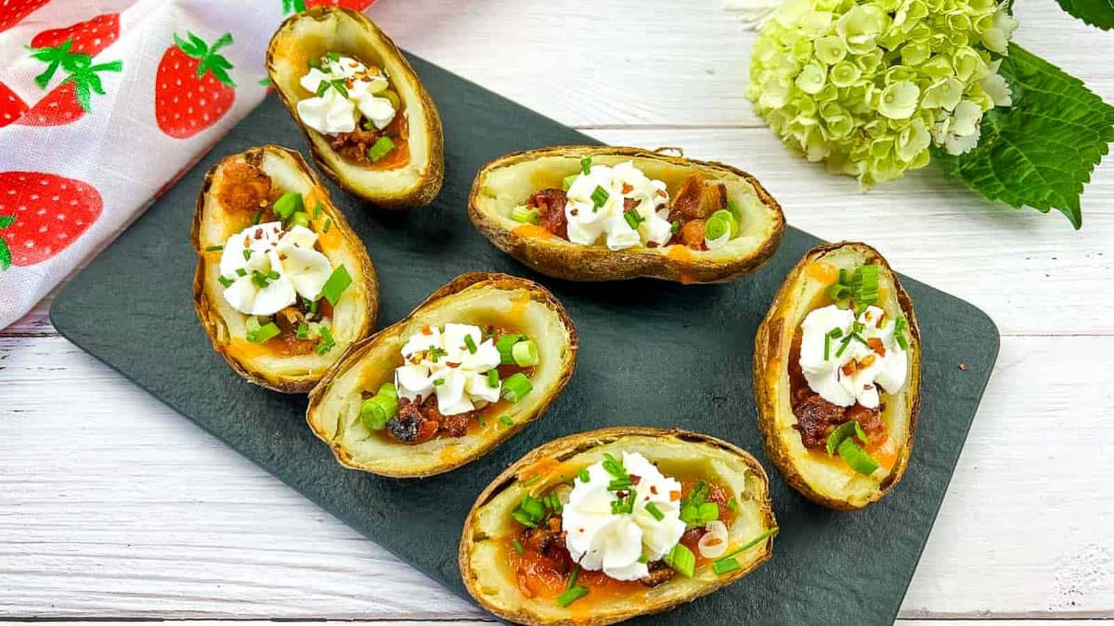 Six Fully Loaded Baked Potato Skins topped with cheese and sour cream.