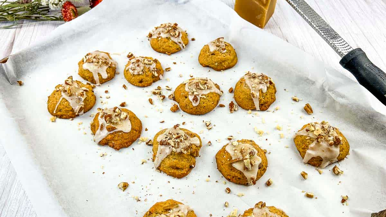 Sweet Potato Cookies on a baking sheet with icing and nuts.