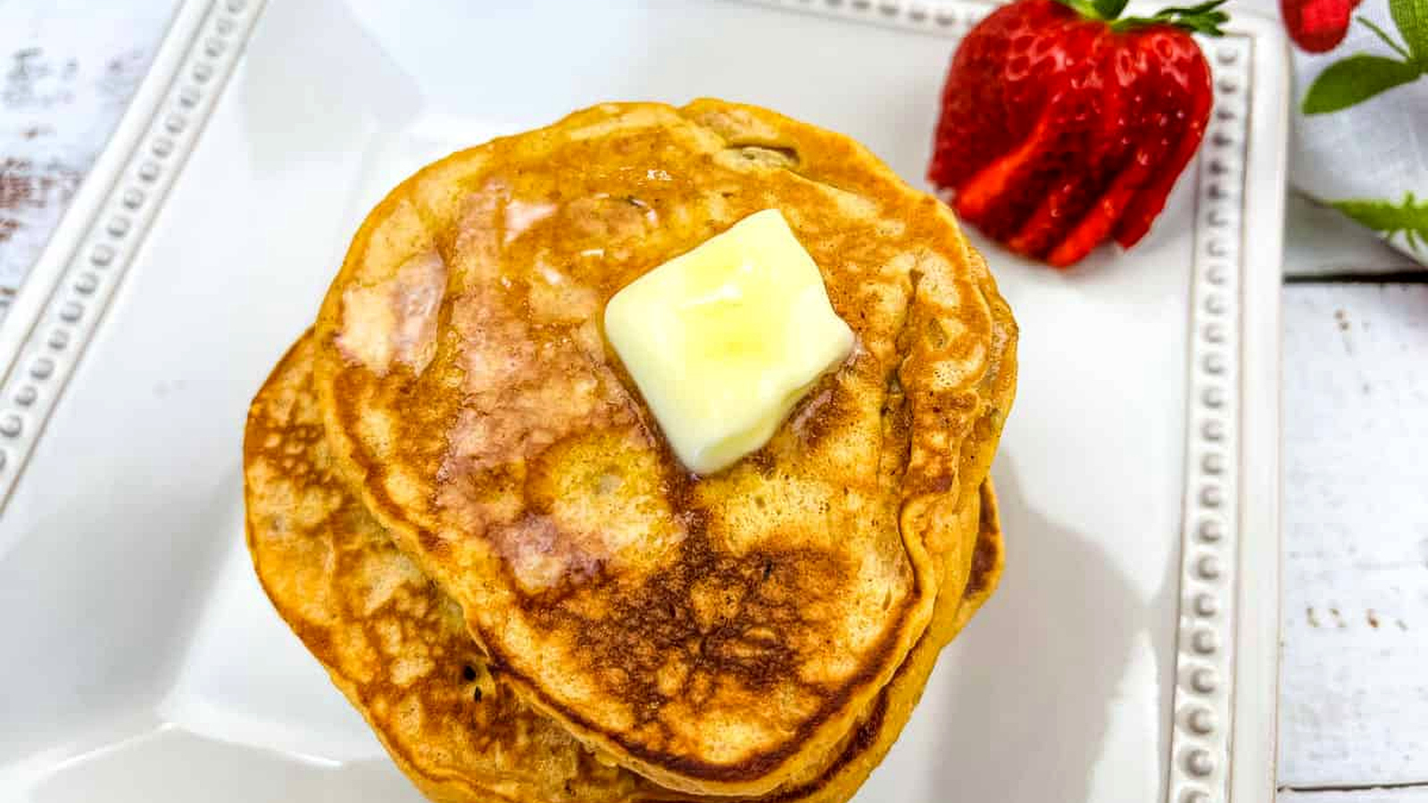 A stack of Sweet Potato Pancakes with a berry.