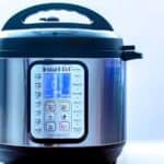 A stainless steel Instant Pot electric pressure cooker with a digital control panel is shown against a plain light background.