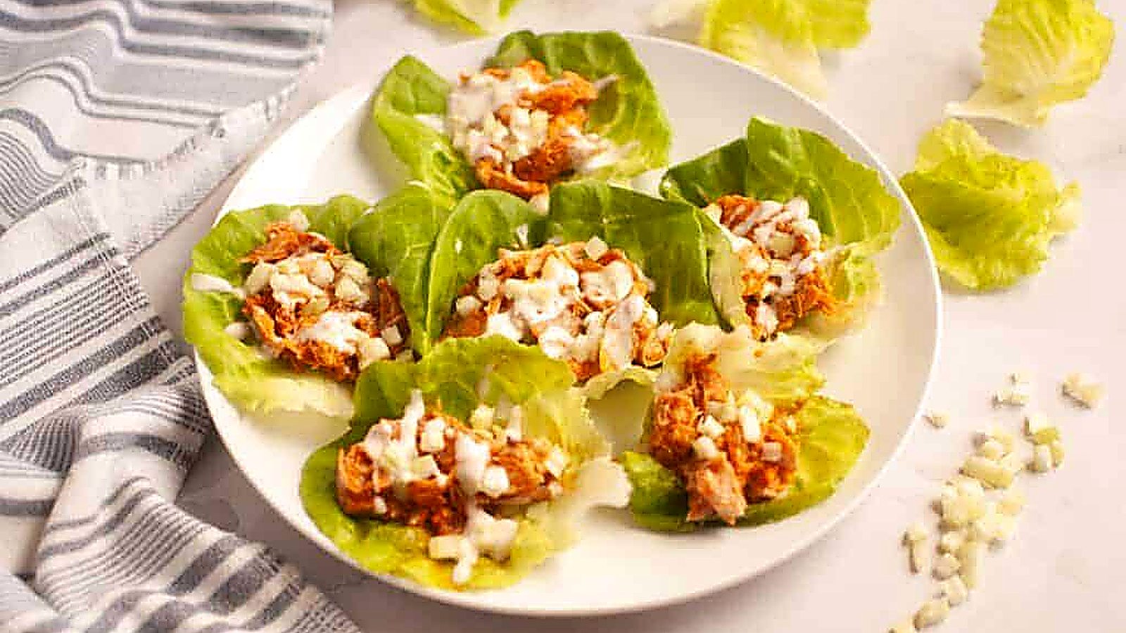 Close-up of a Buffalo Chicken Lettuce Wraps placed on a white plate.