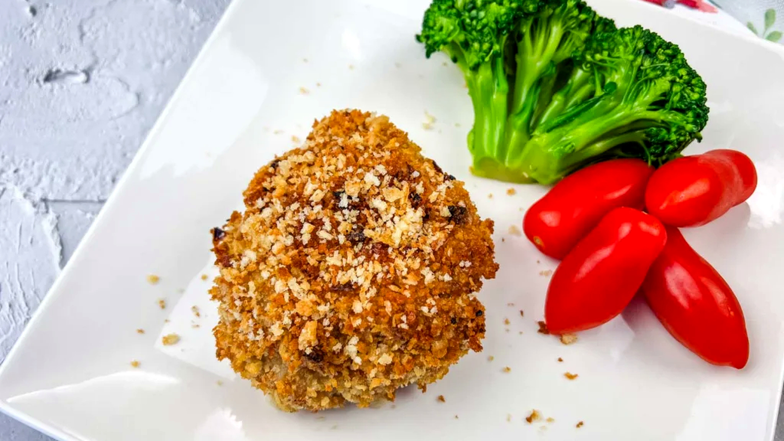 Copycat HelloFresh Crispy Shallot Croquettes on a white plate with tomatoes and broccoli.