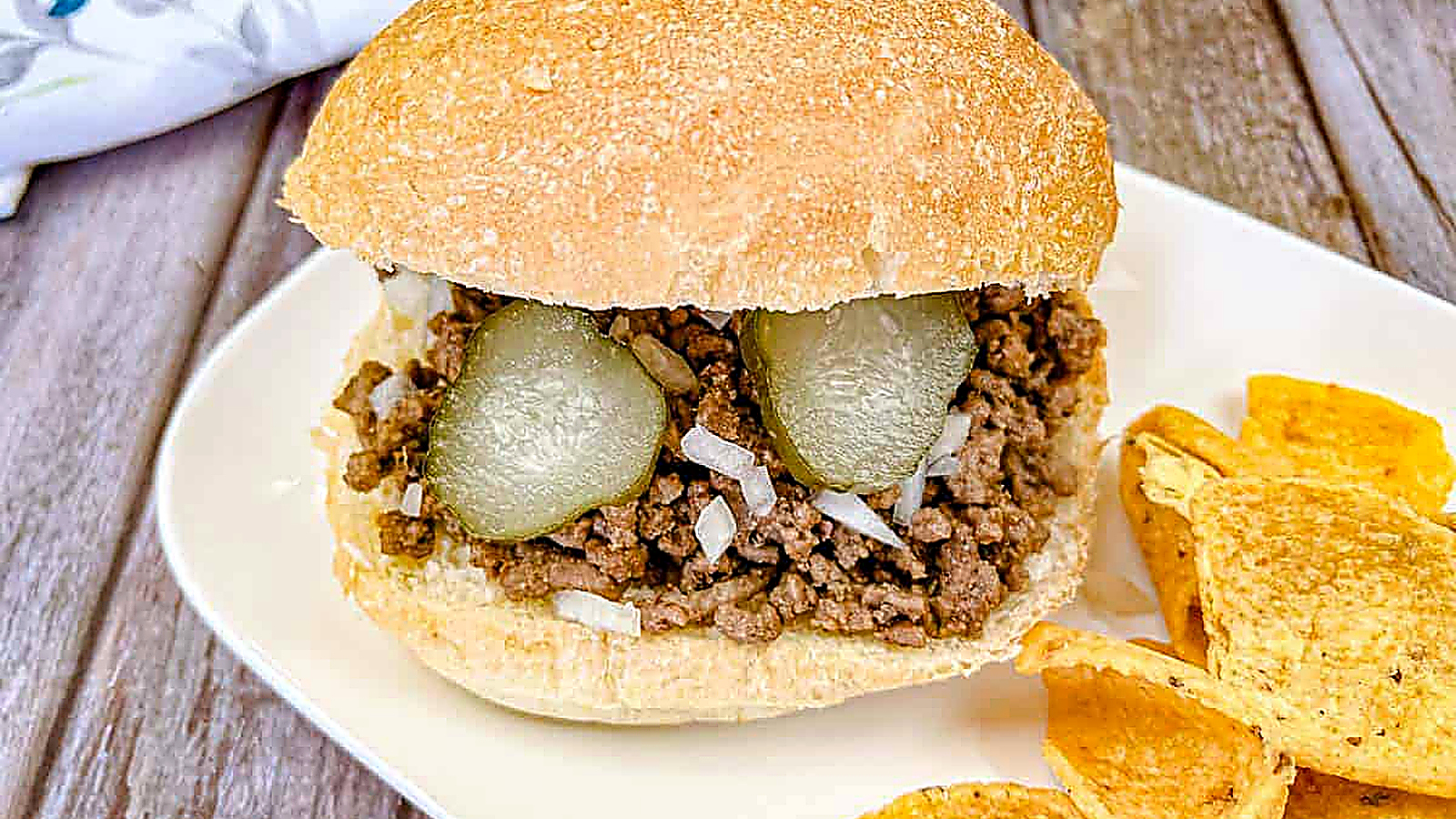 Copycat Maid-Rite Loose Meat Sandwich on a white plate with chips.