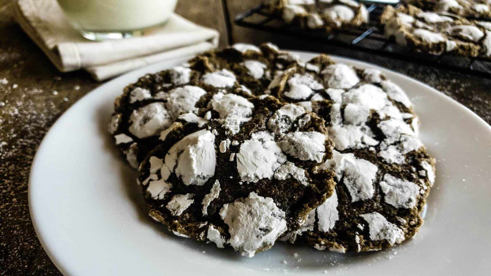 A plate of chai cookies with powdered sugar on it.