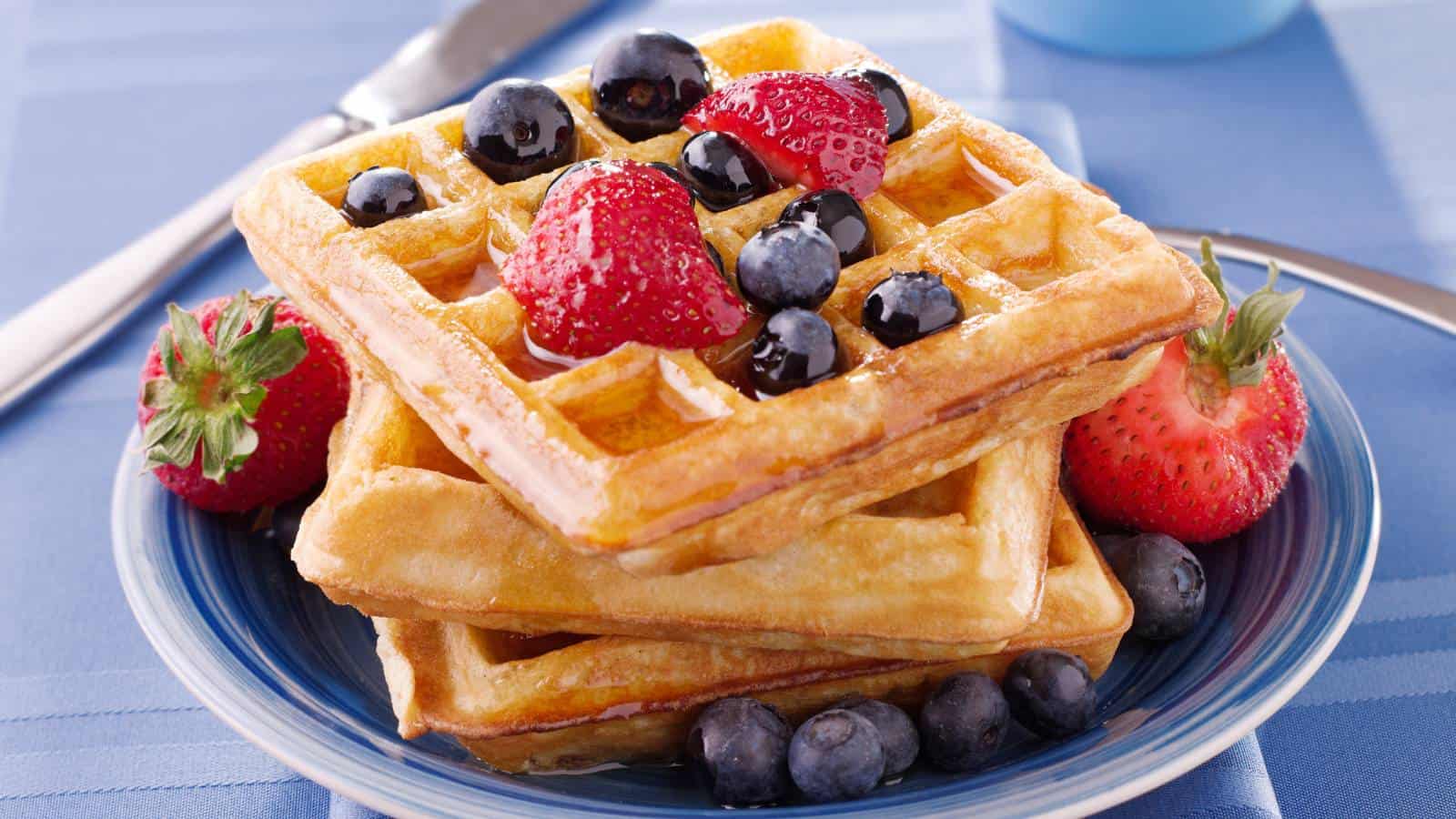 Easy waffle recipe with no milk stack on blue plate.