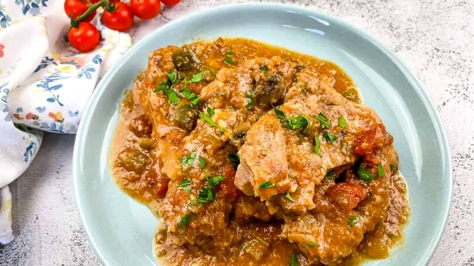 Slow Cooker Swiss Pork Chops on a baby blue serving dish.
