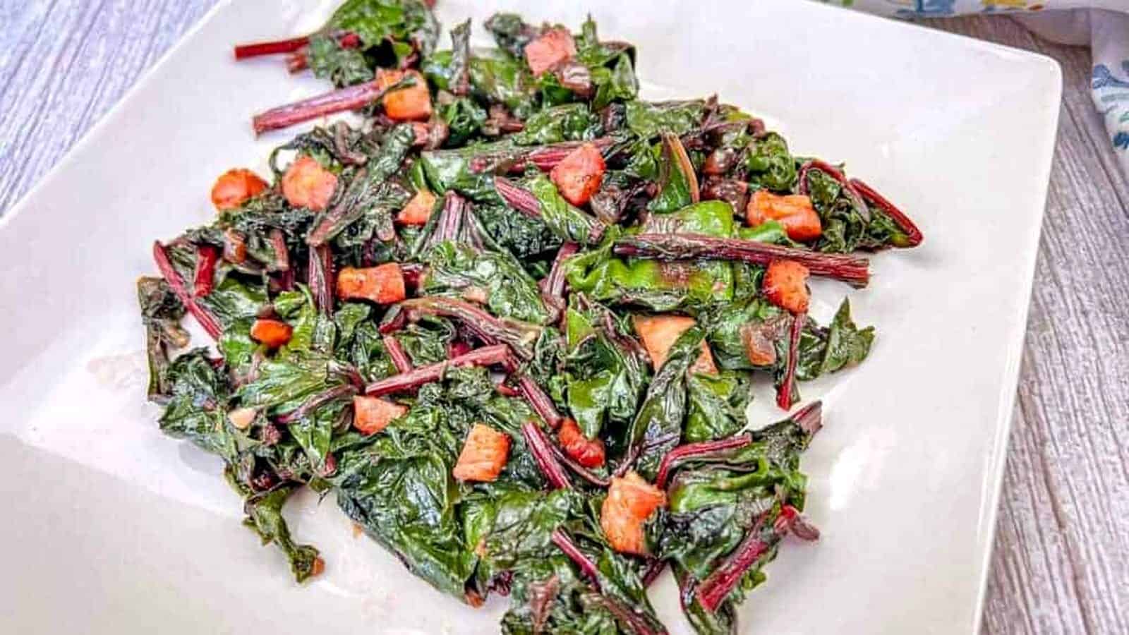 Sauteed Beet Greens with Pancetta on a white plate.