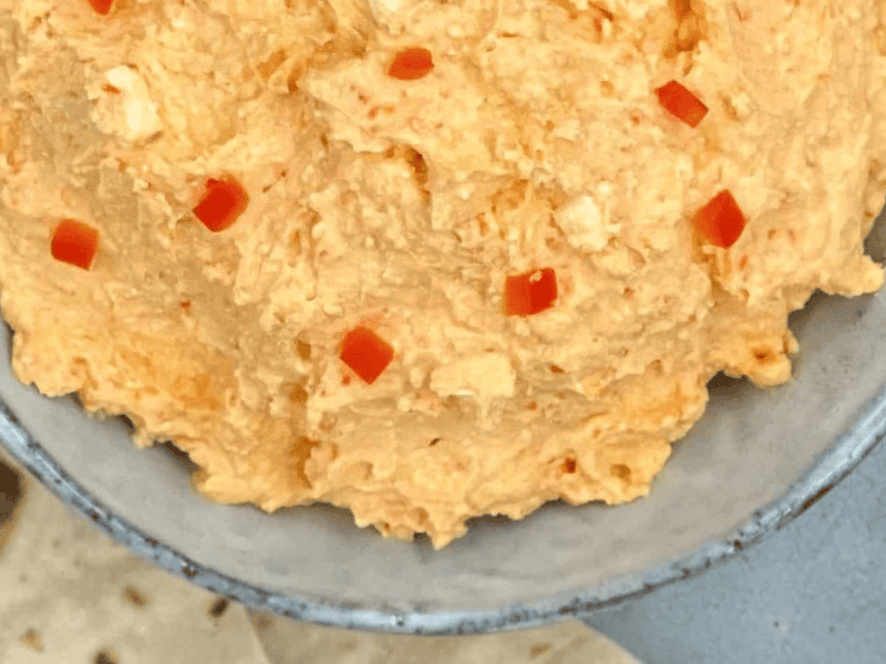 Spicy Greek feta dip in a bowl with pita bread by the side.