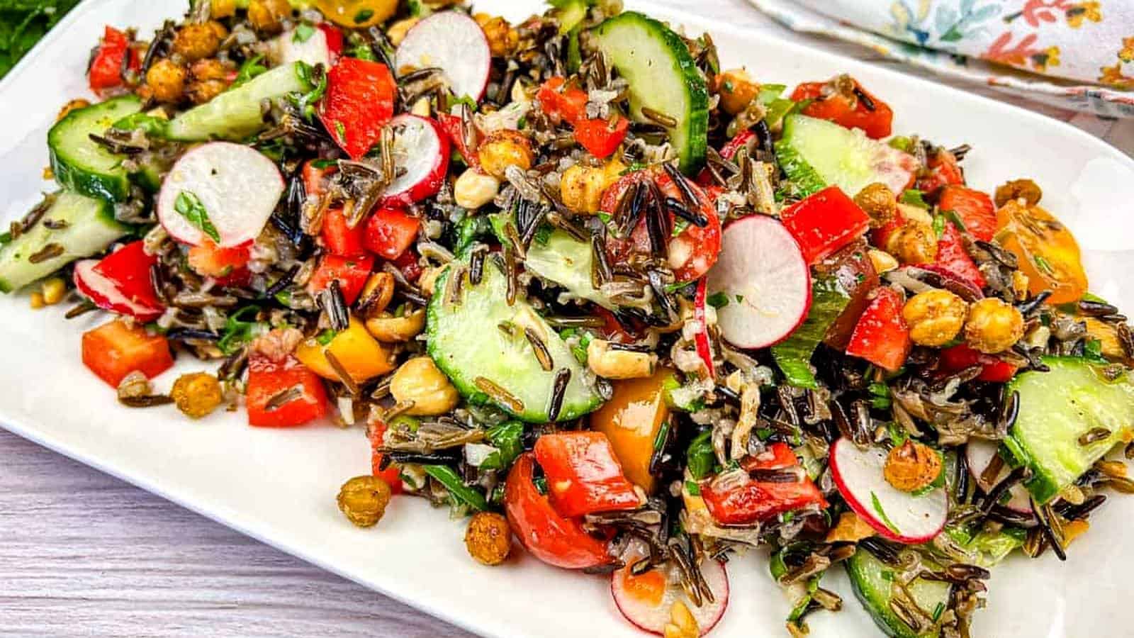 Wild rice salad served on a white rectangular plate.