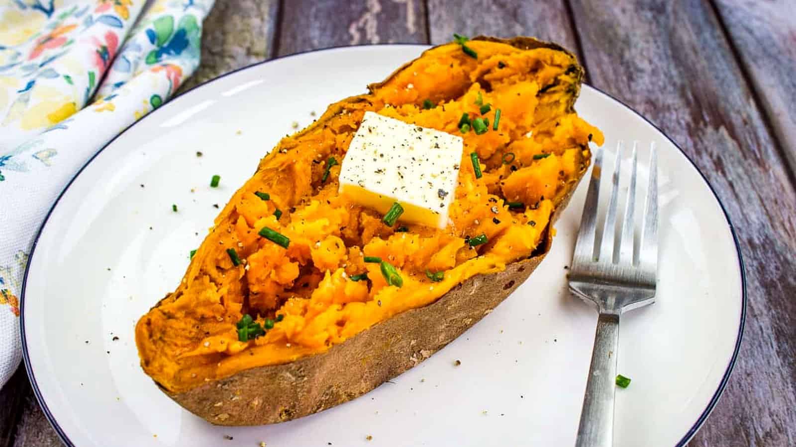 A sweet potato on a plate with a fork.