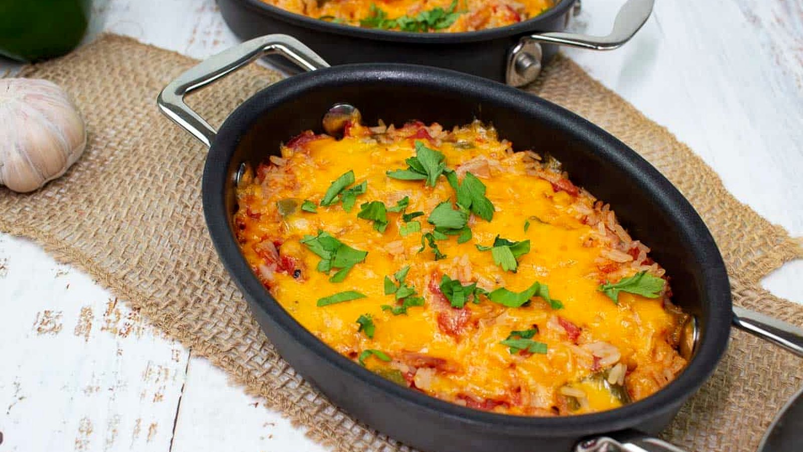 Baked Spanish Rice in two black baking dishes.