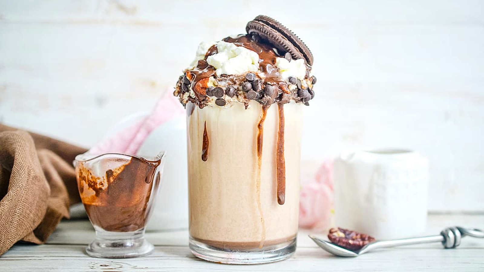 Cookie Dough Milkshake with a spoon and syrup in the background.