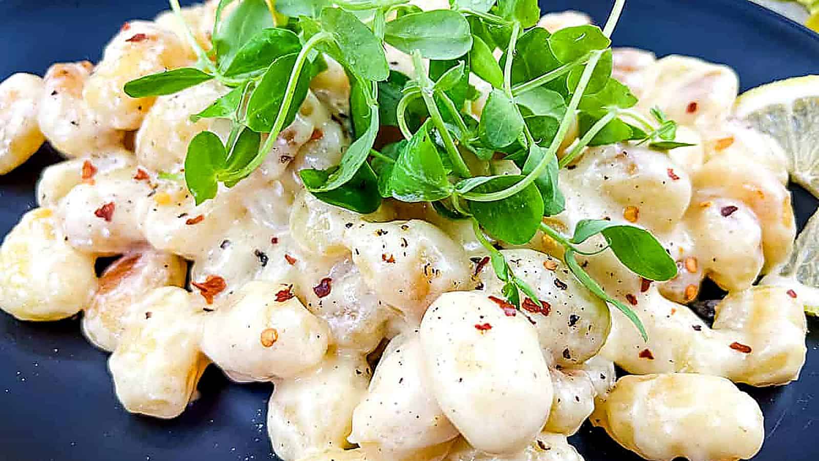 Gnocchi in Lemon-Parmesan Sauce on a black plate.